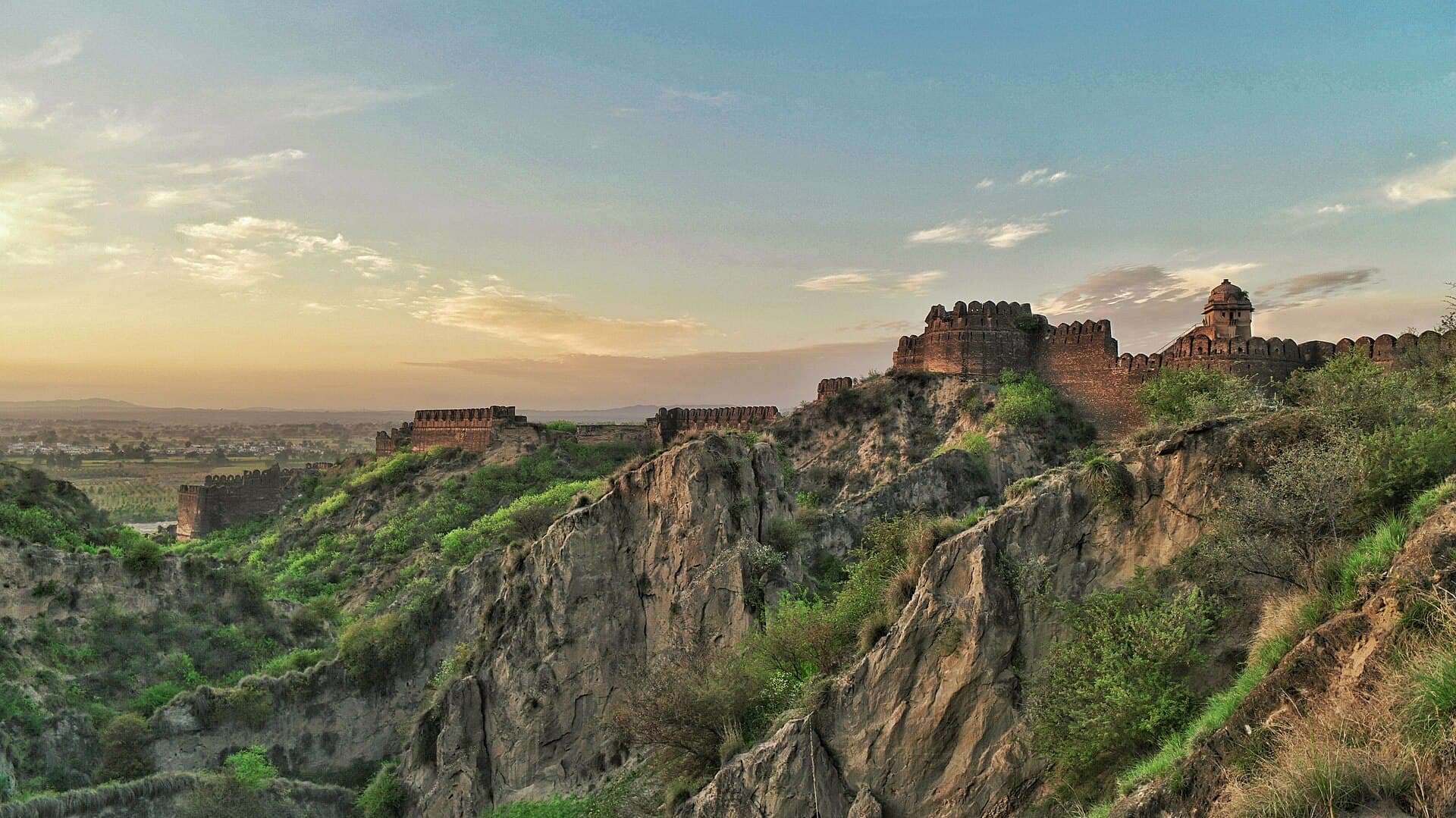 The curtain walls and bastions of Rohtas Fort following the ridge above the valley